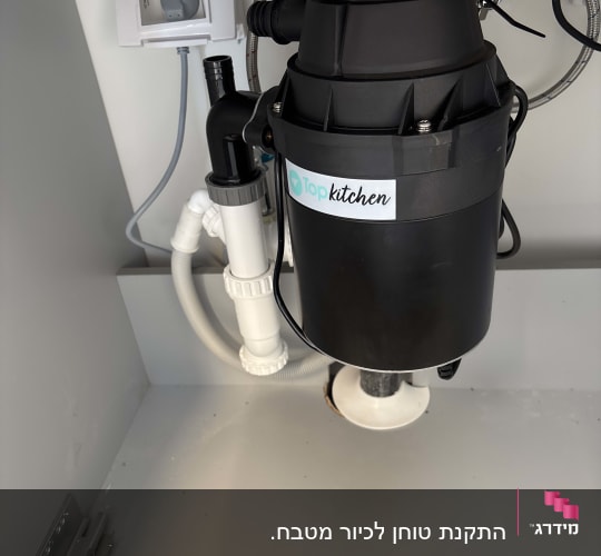 מכשיר טוחן אשפה מתחת לכיור במטבח